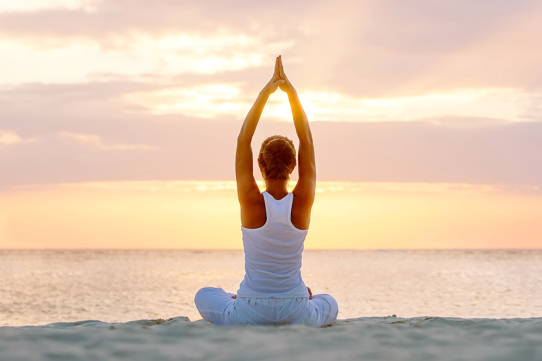 woman in yoga pose on beach at sunrise